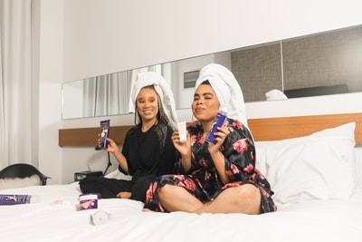 两个女人在浴袍坐在床上
